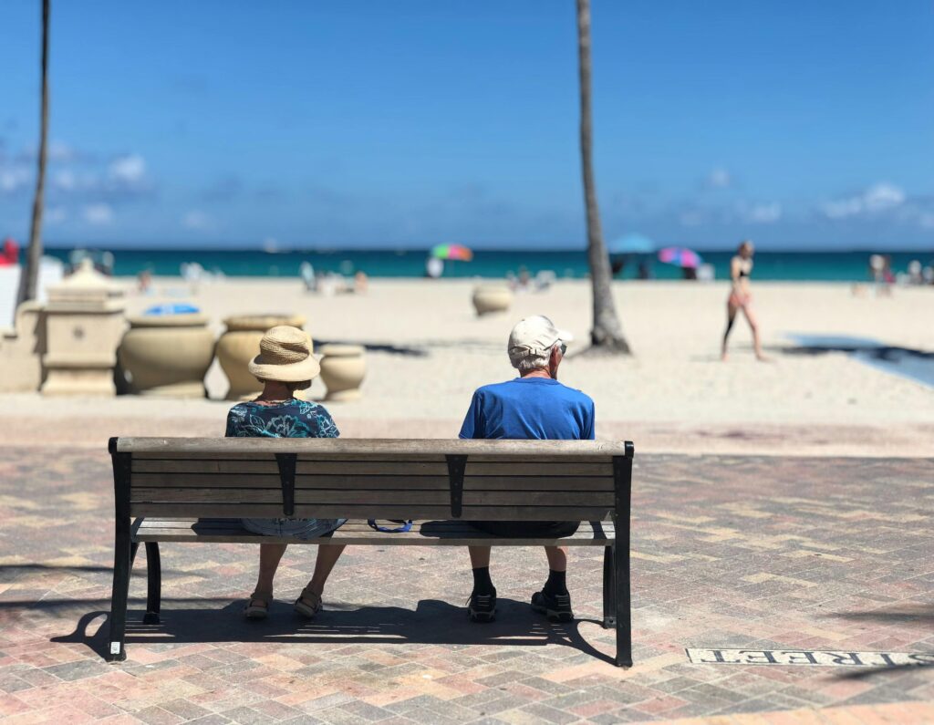 couple sitting on a bench at the beach